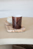 brown luxury candle with intricate Arabesque pattern by Muriḥ styled on a marble tray